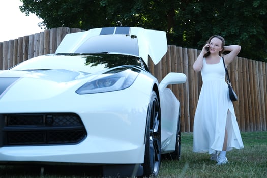 Car woman phone Young smiling red-haired woman uses a mobile phone in her car photo