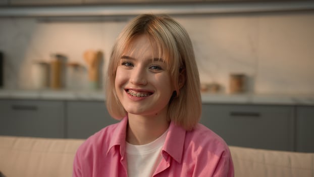 Portrait happy toothy braces teeth health dental oral healthcare smiling laughing positive good mood emotion Caucasian teen student girl woman lady female homeowner renter at home looking at camera photo