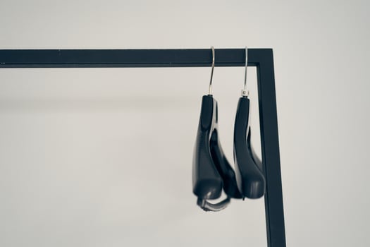 A row of two plastic metal-based clothes hangers. With space to copy photo