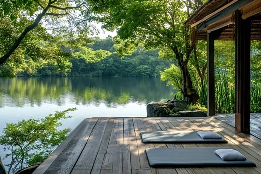 Yoga mats awaiting on wooden deck overlooking serene lake and lush forest photo