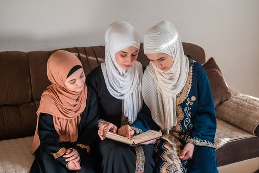 A happy Muslim family reading a Quran at the home photo