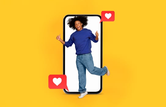 A person joyfully leaps from a smartphone surrounded by love symbols. photo