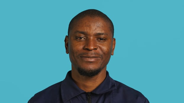 Joyful security guard working protection job presenting chroma key cellphone. Portrait of merry bodyguard showcasing isolated screen mobile phone, isolated over studio background, camera A photo