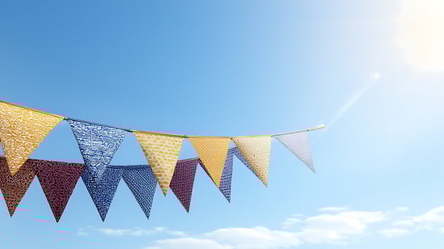 Colorful festive bunting flags fluttering in a clear blue sky with sunlight and clouds photo