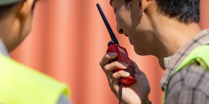 Engineer using a walkie-talkie to communicate logistics on a construction site. photo
