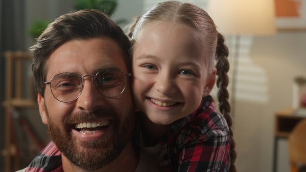 Caucasian family portrait Caucasian man male father good relationship smiling happy looking at camera little girl child kid daughter hugging cuddling embrace dad by neck at home insurance health loan photo