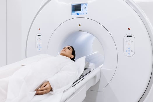 Female finished magnetic resonance imaging, Patient is moving out of MRI scanner capsule. Woman patient lies on an MRI scanner bed. Modern equipped cabinet in private clinic. Banner, free copy space photo