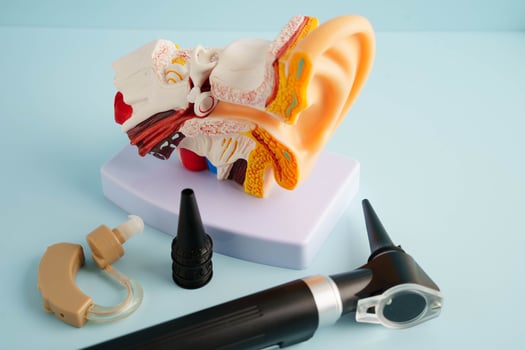 Otoscope with ear model for otolaryngologist or ENT physician doctor examining senior patient ear, hearing loss problem. photo
