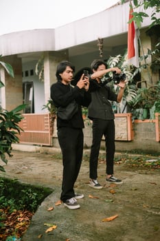 Two young men capturing moments outdoors with phone and professional camera photo