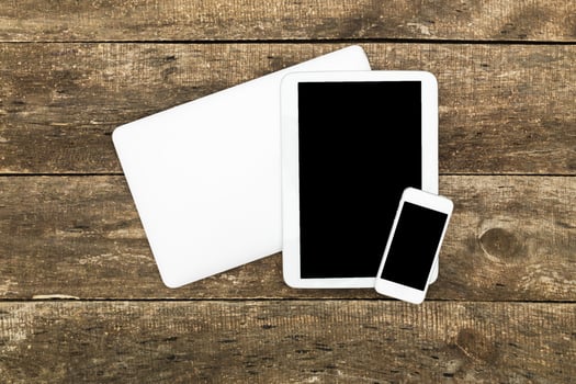Modern technology devices arranged on wooden surface showcasing a laptop, tablet, and smartphone photo