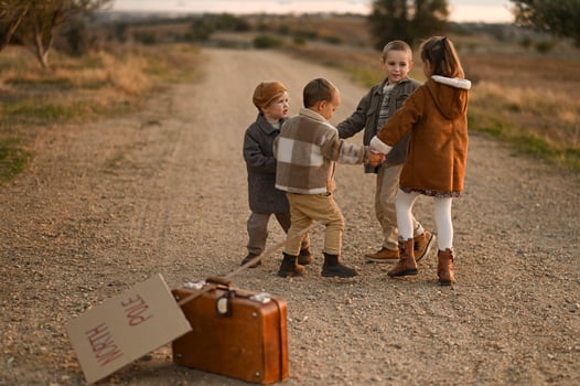 Kids dance playfully on the road, their vintage clothes flowing as they wait beside their suitcase and North Pole sign. photo