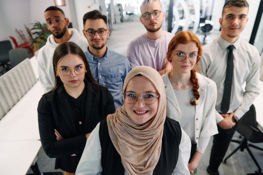 A group of business professionals standing together, taking a well-deserved break from their busy workday, showcasing camaraderie, teamwork, and a moment of relaxation in their dynamic workplace photo