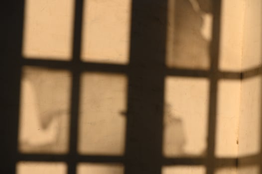 Shadows dance through a sunlit room, revealing textures of history and light play across the walls photo