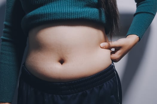 A woman with a belly showing off her stomach photo