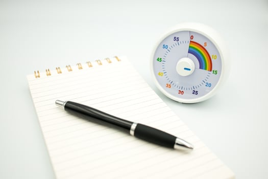 Colorful kids timer with notepad and pen on white background photo