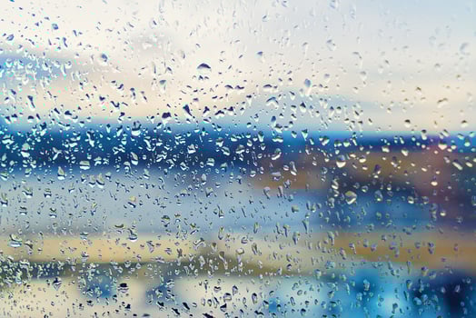 Abstract blurred background street outdoor behind wet window with rain drops, blurred street bokeh. Concept of autumn weather and rainy season, copy space photo