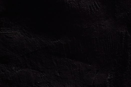 The texture of the black stone surface. Rough uneven wall with scratches with space to copy photo