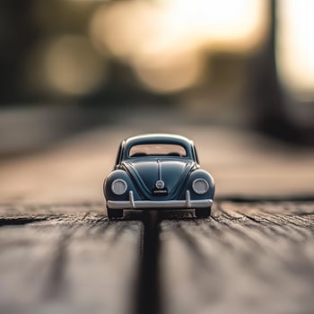 A toy car sits on a wooden table photo
