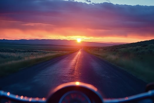 Riding a motorcycle into the sunset on a scenic road photo