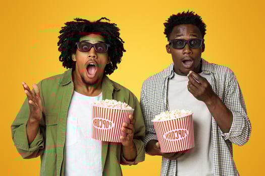 Exciting Movie. Portrait Of Shocked Black Guys In 3d Glasses With Popcorn Buckets In Hands Standing With Open Mouth Over Beige Studio Background, Amazed Male Friends Enjoying Cinema Time, Closeup photo