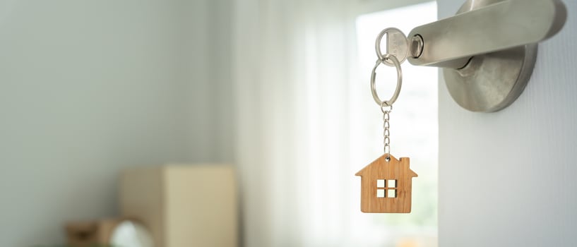 relocation. The key was inserted into the door of the new house, inside the room was a cardboard box containing personal belongings and furniture. move in the apartment, banner photo