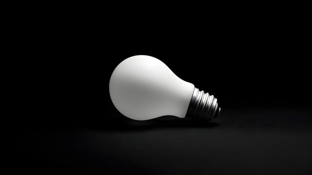 White bulb rests on black background, studio shot, idea concept photo