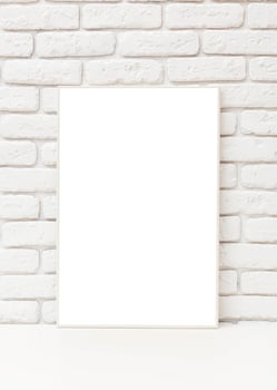 Blank art canvas leaning against a rustic white brick wall indoors during daylight, perfect for creative expression and design photo
