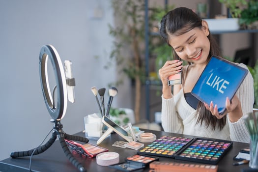 Beauty influencer Asian girl Using Social Media for live streaming on Smartphone like to her channel. Like, Follower, Comment photo