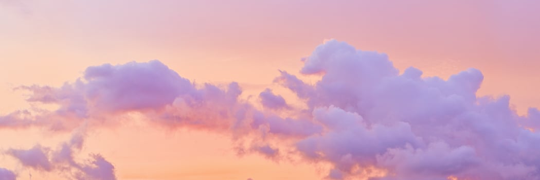 Aesthetic Pastel Sunset, violet fluffy clouds on pink peach colored sky, dreamy cloudscape pastel tones, surreal dreamscape at sunset, soft colorful heaven, wide banner, panoramic view. photo
