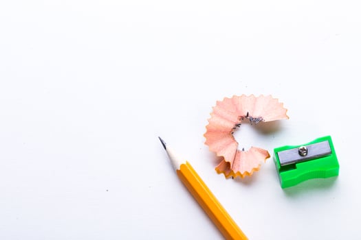 Pencil sharpening supplies on white background with pencil shavings and sharpener in bright colors photo