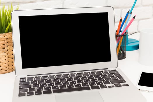 Minimalist workspace featuring a laptop, stationery, and desk lamp with vibrant colors, ideal for productivity and creativity photo