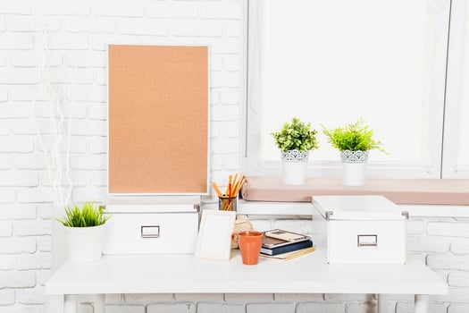 Modern workspace design featuring a corkboard, plants, and organized stationery in a bright, minimalistic setting photo