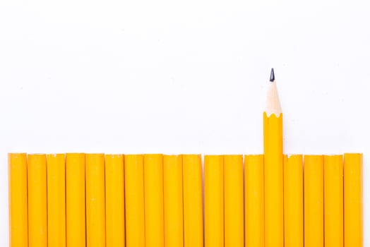 Yellow pencils arranged with one pencil standing out against a white background showcasing creativity and uniqueness in a simple design photo