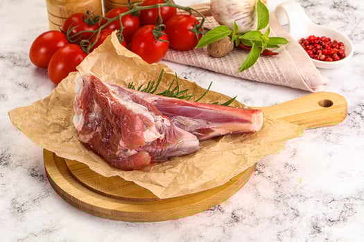 A piece of meat on a cutting board with tomatoes and herbs photo