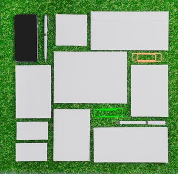 Assorted stationery items arranged on green grass in a creative layout under natural light photo