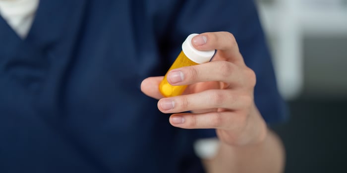 Medical student analyzing medication dosage with a prescription bottle, focusing on pharmaceutical education. photo