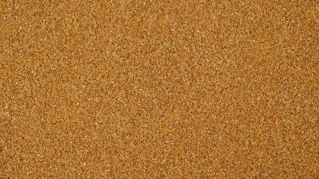 Golden sand background with fine texture of desert or beach. Granules small and tightly packed, uniform and natural pattern. Ideal for yellow textures, summer sun holiday concept or design elements. photo