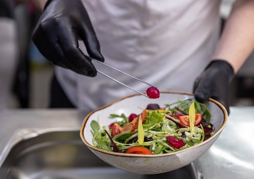 Chef using tongs to add pickled onion photo