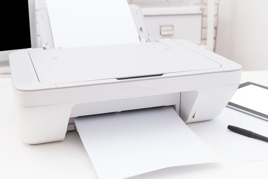 Printer in a modern office setting with white papers being printed during the workday photo