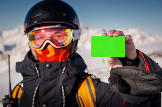 Girl in winter gear holding ski pass and snowboard smiling. Concept for illustration of ski entrance fee, demonstration of qualified instructor certificate at ski resort photo