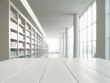 Empty white wooden tabletop on blurred background of modern library with big window and bookshelves photo