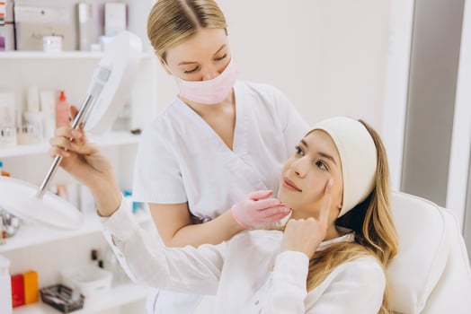 Doctor showing botox injection results to a patient with a mirror in a medical spa center photo