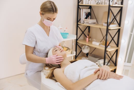 Beauty professional massaging client's face during relaxing skincare procedure in spa treatment room photo