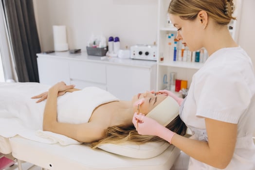 Professional beautician performing a facial treatment on a client in a spa or beauty salon photo