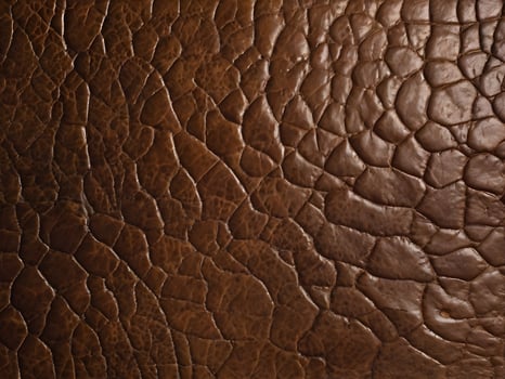 A macro photograph of textured leather, displaying its aged surface and natural wear. photo