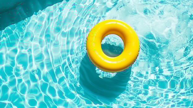 Yellow inflatable ring floating in swimming pool with turquoise water photo