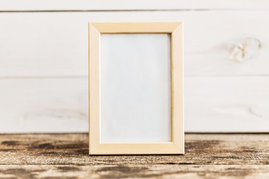 Empty picture frame on rustic wooden surface with soft natural background photo