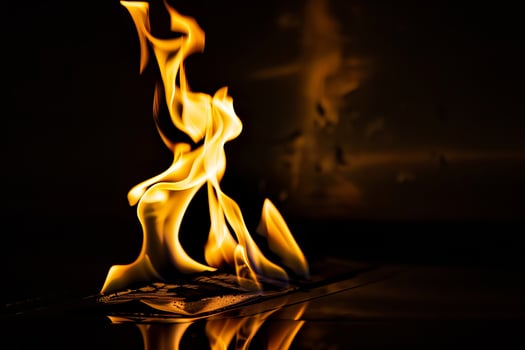 Dramatic flames engulfing paper with fiery glow in dark room photo
