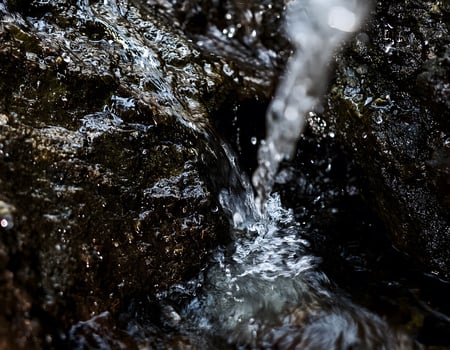 Natures Purity. Clear Water Moving Through Deep Black Stones photo