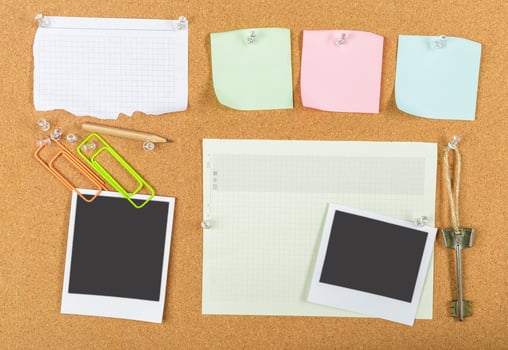 Bulletin board filled with blank notes, photos, and office supplies in a creative workspace environment photo